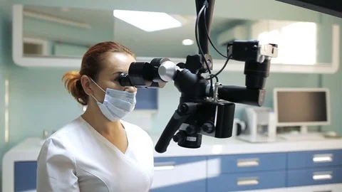 Dentist using dental microscope in dentistry Stock Footage