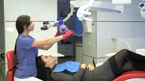 Dentist using dental microscope in dentistry Stock Footage 128628640
