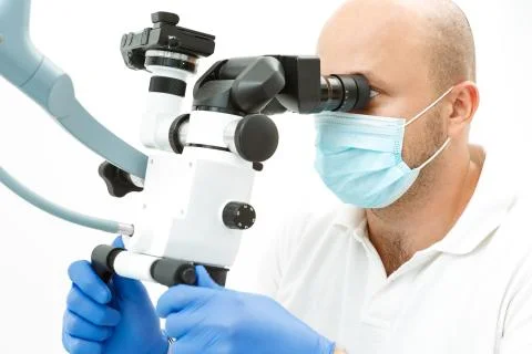 Dentist using dental microscope during inspection Stock Photos