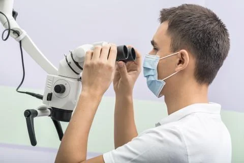 Dentist using a dental microscope 스톡 사진
