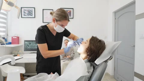 Dentist using a dental mirror for a professional oral examination of a boy Stock-Footage 316083256