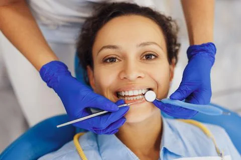 Dentist using dental mirror to provide medical procedure Stock Photos