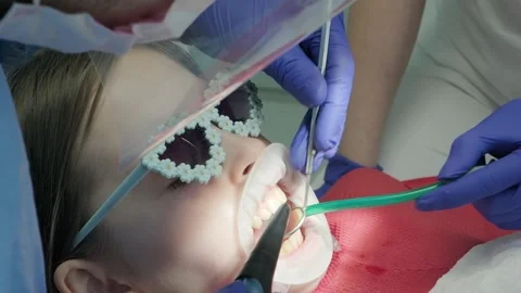 Dentist using saliva ejector tube during child treatment Stock Footage 336665696