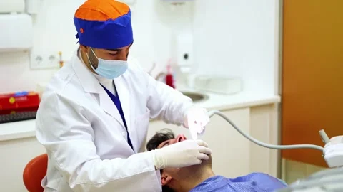 Dentist using suction tool during dental procedure Stock Footage 295627370