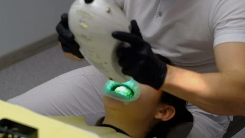 Dentist whitens a patient's teeth Stock Footage 124578850
