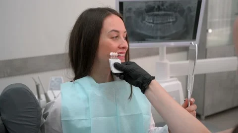 Dentist at work. Matching the shades of the implants using shade guide Stock Footage 175234980