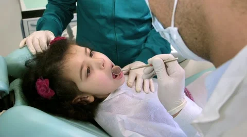 Dentist working with assistant, checking teeth of young baby girl Stock Footage 21245226