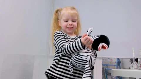 Dentistry brush teeth toys learn to brush teeth. Girl playing with a zebra toy Stock Footage 278483249