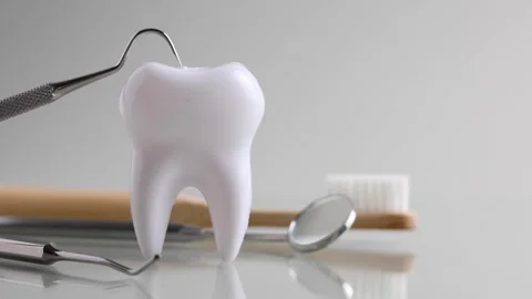 Dentistry concept. Model of a tooth and dental instruments on a colored Stock Footage 245234366