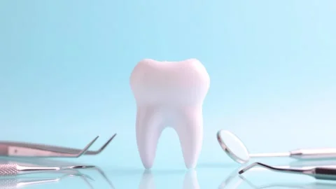 Dentistry concept. Model of a tooth and dental instruments on a colored Stock Footage 245234401