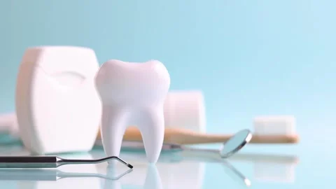 Dentistry concept. Model of a tooth and dental instruments on a colored Stock Footage 245853704
