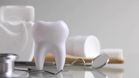 Dentistry concept. Model of a tooth and dental instruments on a colored Stock Footage 246563119