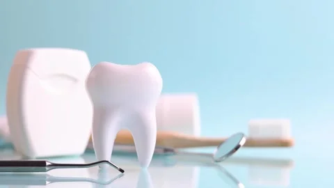 Dentistry concept. Model of a tooth and dental instruments on a colored Stock Footage 247341271
