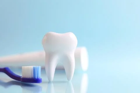 Dentistry concept. Model of a tooth and dental instruments on a colored Stock Photos