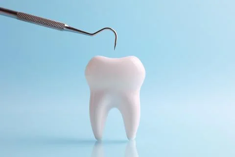 Dentistry concept. Model of a tooth and dental instruments on a colored Stock Photos