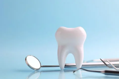 Dentistry concept. Model of a tooth and dental instruments on a colored Foto stock