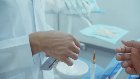 In dentistry, doctor hands veneer samples to patient. 4K slow motion video Stock Footage 104960152