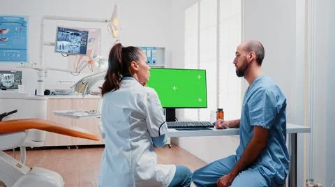 Dentistry team analyzing teeth x ray and green screen on monitor Stockfoto's