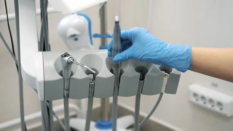Dentists hand in protective gloves putting dental instrument in place. Stock Footage 317170997