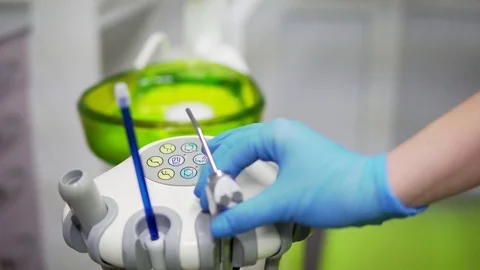Dentists hands take the medical tools and pouring water out at dental clinic Stock Footage