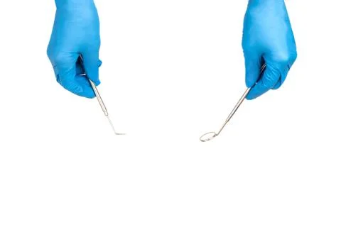Dentist's hands with tools isolated on white. Stock Photos