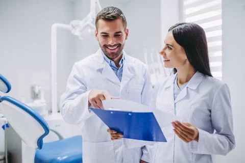Dentists looking at clipboard Stock Photos