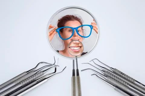 Dentist's tools and two dentist's mirrors with woman's smile Foto stock