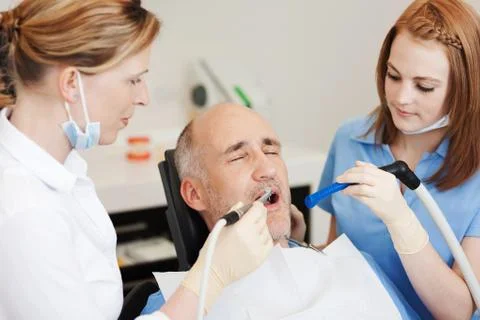 Dentists using dental drill and sucker Stock-Fotos