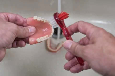 Denture cleaning with brush Stock Photos