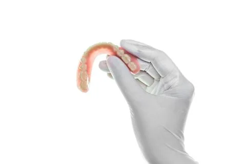 Denture in hand on white background Foto stock