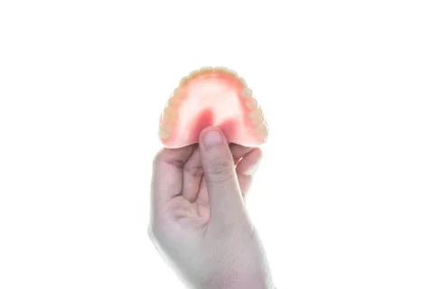 Denture in hand on white background Stock Photos