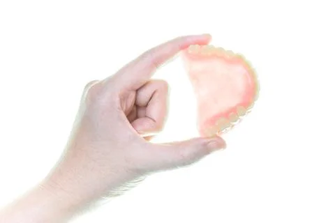 Denture in hand on white background Stock Photos