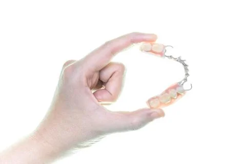 Denture in hand on white background Stock Photos