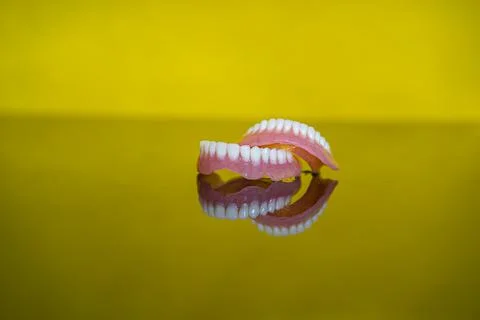Dentures close-up on a yellow background Stock Photos