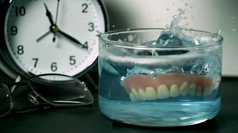 Dentures Falling On Cleaning Glass Slow Motion 2000fps Stock Footage