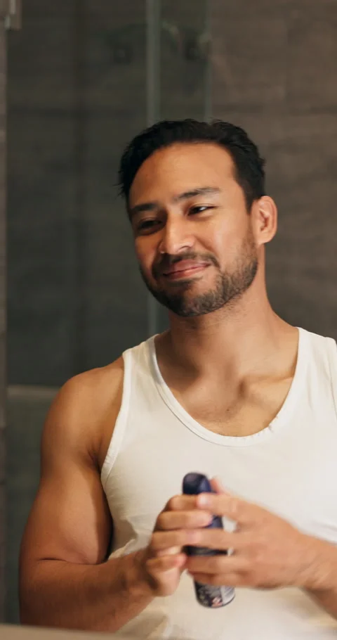 Deodorant, happy and man by mirror in bathroom at house for hygiene, odor or Vidéo 340878384