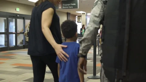 Departing soldier saying goodbye to his family at an airport Stock Footage