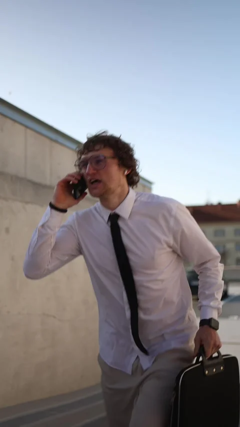 Department manager talks on phone while rushing to work and running late Stock Footage 345993648