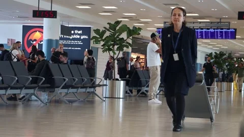 Departure gate attendant is pulling a rack for measure the size of luggage Stock Footage 318407961