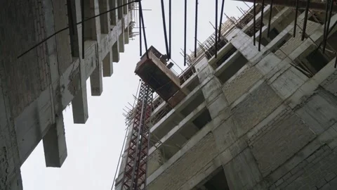 Depicting of buildings in construction with elevator suspended between Stock Footage 306340206