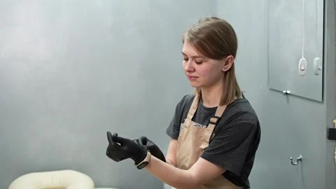 Depilation master puts on black protective gloves before the procedure Stock-Footage 264856797