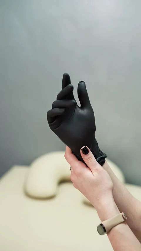 Depilation master puts on black protective gloves before the procedure Stock Footage 264857646