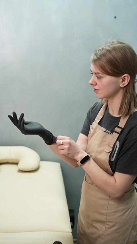 Depilation master puts on black protective gloves before the procedure Stock-Footage 264857699