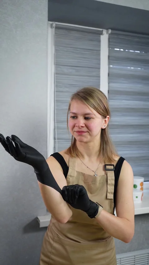 Depilation master puts on black protective gloves before the procedure Stock Footage 269943648