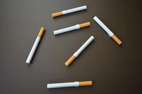 Deployed cigarettes on a brown matte background Stock Photos