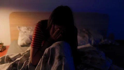 Depressed adolescent crying in dark bedroom holding hands over face in pain Stock Footage 336670037