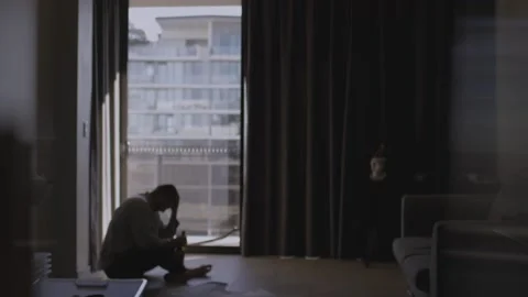 Depressed and sad man drinks alcohol by himself looking outside Stock Footage 158345103