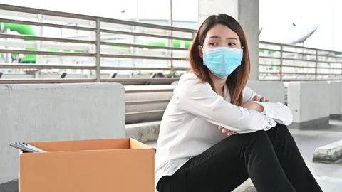 Depressed Asian woman being fired lose the job wearing mask sitting exhausted Stock Footage