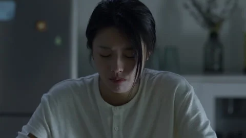 Depressed asian woman crying while eating dinner alone at night 스톡 동영상 333801737