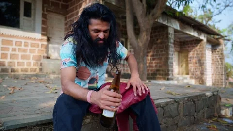 Depressed bearded man muses while drinking liquor outdoor Video stock 303962302